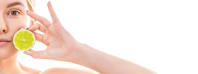 The half of the young woman face with a lime on the white background