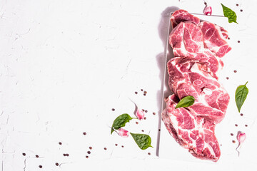 Raw pork meat, sliced cuts with dry sumac, fresh garlic and basil leaves