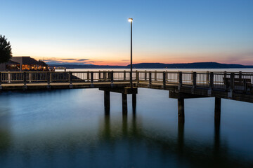 Obraz premium Street Light on Dock Over Water During Blue Hour