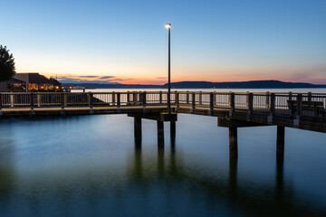 Street Light on Dock Over Water During Blue Hour