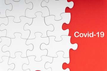 Fototapeta premium COVID-19 text with jigsaw puzzle on red background. Covid-19 and Coronavirus Concept