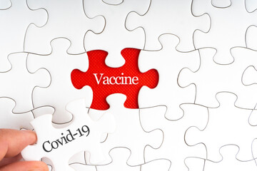 Fototapeta premium COVID-19 VACCINE text with jigsaw puzzle on red background. Covid-19 and Coronavirus Concept