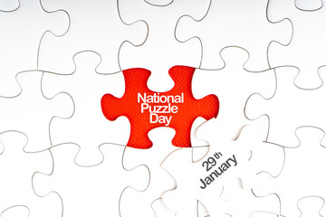 NATIONAL PUZZLE DAY  text with jigsaw puzzle on red background. Education and Holiday Concept