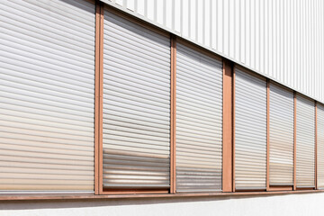 shutters on a wall, windows on a metal wall, closed shutters on all windows with alu rollable...