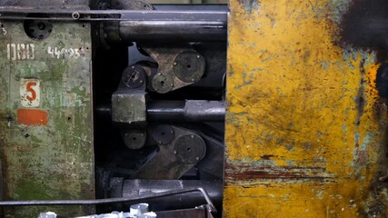 Factory for the production of spare parts for cars and tractors. The site of non-ferrous casting and heat treatment. Powerful press for melting aluminum blanks in close-up.