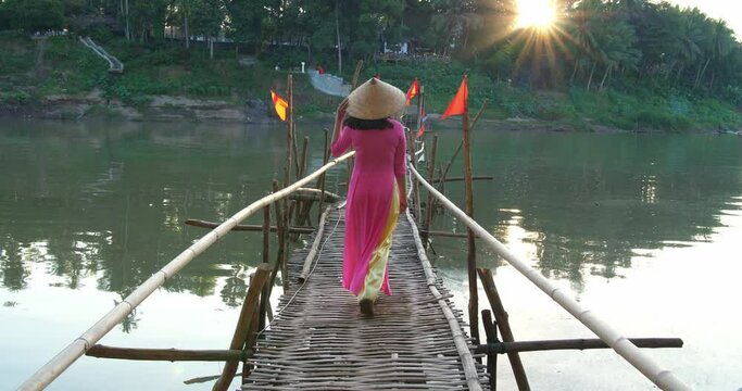 Vietnamese Girl Walking On Bamboo Bridge With Sunlight
