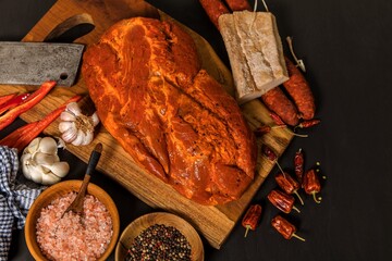 Meat, Pork neck in marinade and on a chopping boardon. Raw steak meat pork neck on chopping board with chili. Raw meat for grilling. Black background.