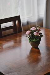 flores de plastico en macetero sobre una mesa, luces y colores otoñales