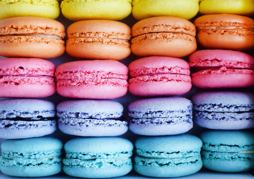 Multicolored  rainbow macaroon desserts as background. Delicious french macaroons with filling.
