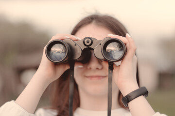 Selective focus to binoculars in the hand of girl. 
