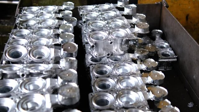 Factory for the production of spare parts for passenger cars and tractors. The worker puts the melted aluminum billet on the cart. Lots of ready-made close-up details.
