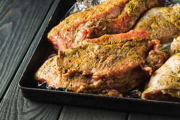 Raw meat veal and chicken legs on a baking sheet are prepared for baking in the oven. The national meat dish is prepared on the eve of the holidays