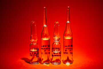 transparent medical glass vials on a red background