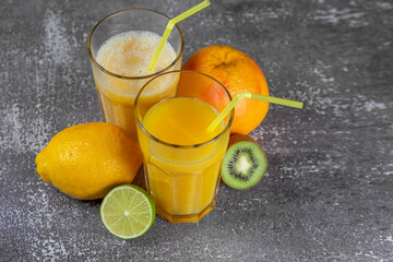 Freshly squeezed orange juice and banana and orange smoothies in tall glasses
