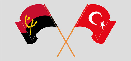 Crossed and waving flags of Angola and Turkey