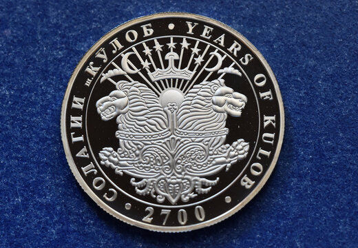 a silver coin from tajikistan with a shield with two lions
