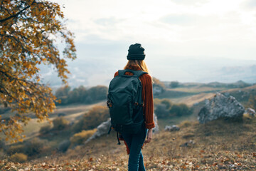woman hiker with backpack admires nature mountains landscape