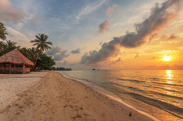 bungalow on a tropical beach at sunset