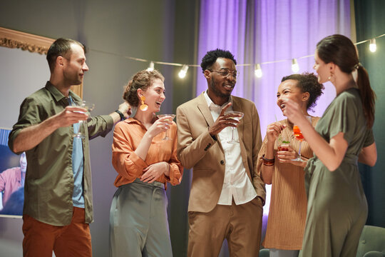 Waist Up Portrait Of Diverse Group Of Friends Having Fun And Drinking Cocktails At Home Party