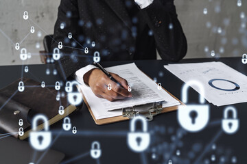 African American businesswoman in formal wear signing the contract to prevent probability of risks in cyber security. Padlock Hologram icons over the working desk. Women in business concept.