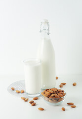 A glass with almond milk and the bowl with almonds