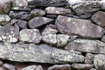 Rough gray stone wall with patches of light green lichen