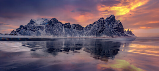 Vestrahorn mountaine on Stokksnes cape in Iceland during sunset with reflections. Amazing Iceland nature seascape. popular tourist attraction. Best famouse travel locations. Scenic Image of Iceland