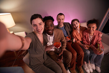 High angle view at friends taking selfie photo while enjoying party at home