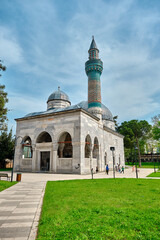 Green mosque (yesil camii) in Nicaea (iznik) sunny day in center of the city groups of children playing game near the mosque and public park covered by many green plants.