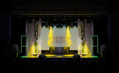 The stage of the theater illuminated by spotlights from the auditorium
