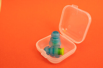 Silicone ear plugs for human ears on red background