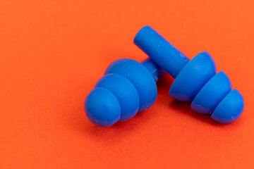 Silicone ear plugs for human ears on red background