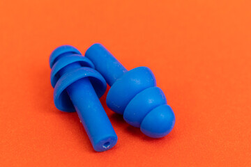 Silicone ear plugs for human ears on red background