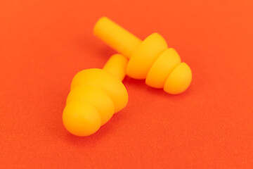 Silicone ear plugs for human ears on red background