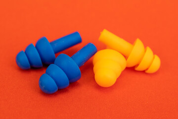 Silicone ear plugs for human ears on red background