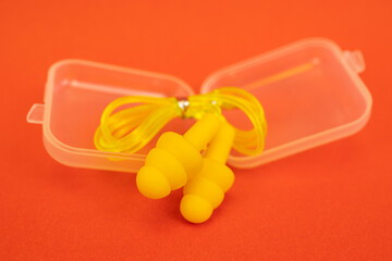 Silicone ear plugs for human ears on red background