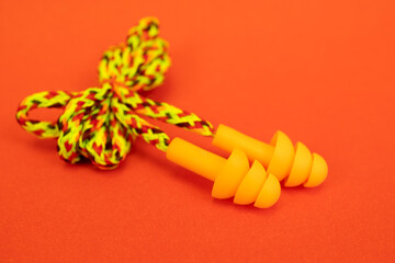 Silicone ear plugs for human ears on red background
