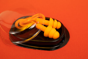 Silicone ear plugs for human ears on red background