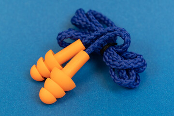 Silicone ear plugs for human ears on blue background