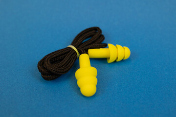 Silicone ear plugs for human ears on blue background