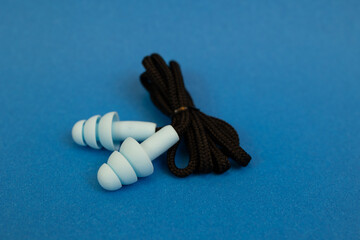 Silicone ear plugs for human ears on blue background