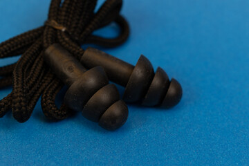 Silicone ear plugs for human ears on blue background