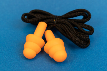 Silicone ear plugs for human ears on blue background