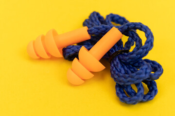 Silicone ear plugs for human ears on yellow background