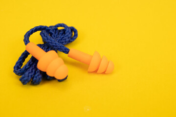 Silicone ear plugs for human ears on yellow background