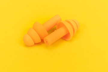 Silicone ear plugs for human ears on yellow background