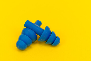 Silicone ear plugs for human ears on yellow background