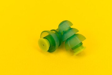 Silicone ear plugs for human ears on yellow background