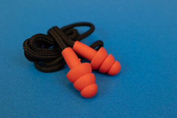 Silicone ear plugs for human ears on blue background