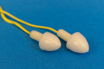 Silicone ear plugs for human ears on blue background